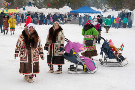 Russkinskaya, Surgut, Russia, 03/23/2019: open traditional holiday of reindeer herders and fishermen, indigenous peoples of Siberia. Women in national dress Khanty with children.のeditorial素材