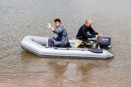 Ufa, Russia, 06.25.2020. Fishermen are preparing to sail in an inflatable boat with an outboard...