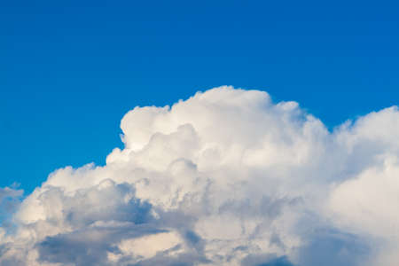 Blue sky with massive cumulus clouds at the bottom of the frame.の写真素材