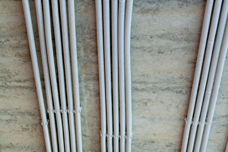 Rows of electrical cables laid in the corrugates on the ceiling. Wiring and electrical installation.