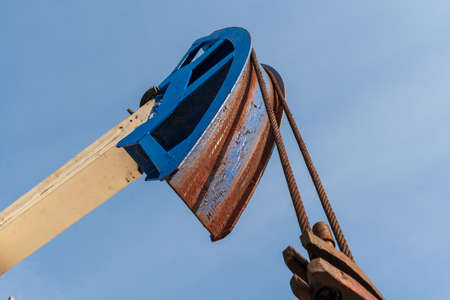 Brightly colored oil pumps produce oil or gas. Detail of the oil pump against the blue sky.