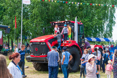 Ufa, Chishmy, Russia, 06.05.2021. National Tatar-Bashkir holiday Sabantuy. Exhibition of agricultural machinery. Children play on the Kirovets tractor.のeditorial素材