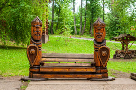 Kungur, Russia, 07.22.2021 A stylized wooden bench in the shape of two Russian heroes. The territory of the tourist complex is the Kungur Ice Cave.のeditorial素材