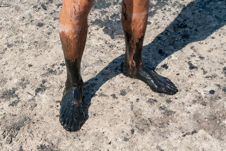 Men's feet smeared with curative mud. Salty, mud medicinal lakes of Sol-Iletsk.の写真素材
