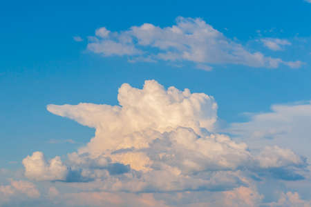 A large bizarre cloud in the rays of the setting sun. rain cloud formation.の写真素材