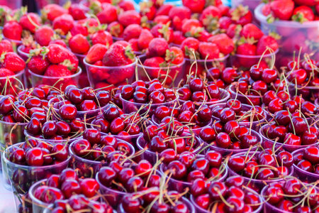 red berries. Showcase of the retail market for vegetables and fruits. Ripe apricots. Fresh cherries...