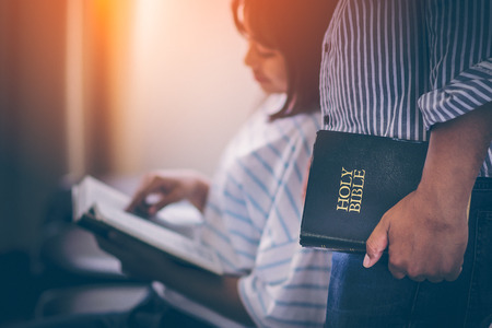 Mature men standing recommendations, and share the gospel in the Bible to teens. Teen fingers pointing at letters within the Bible and smiled with a sense of exhilaration. The concept of Christianity.の写真素材