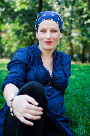 Green-eyed beautiful young woman dressed in blue and with a bandanna in natureの写真素材