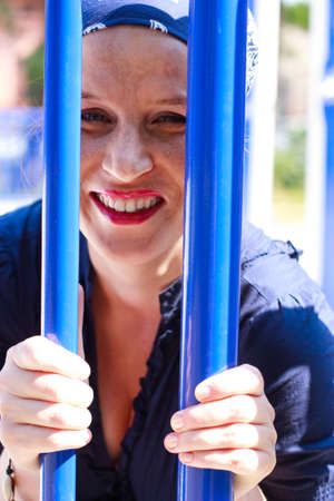 Green-eyed beautiful young woman with blue bars laughing
