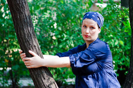 Green-eyed beautiful young woman dressed in blue in natureの写真素材