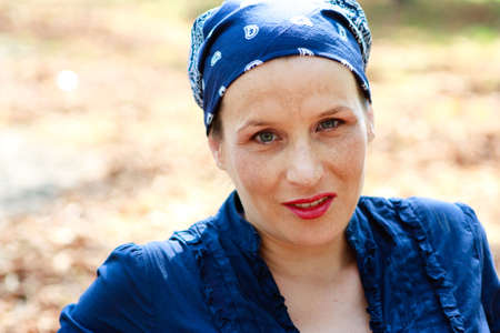 Green-eyed beautiful young woman dressed in blue smilingの写真素材