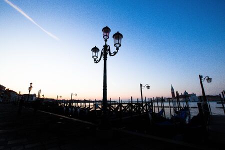 Beautiful old street lamp silhouette in Venice, Italy at sunriseの写真素材