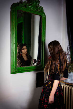 Girl standing in front of wall  mirrorの写真素材