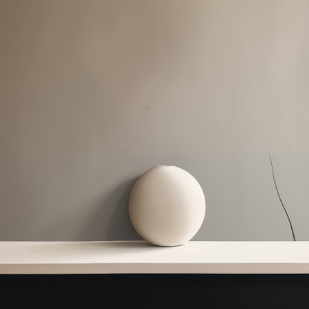 White ceramic vase on a white shelf against a gray wall.の素材