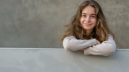 Portrait of a beautiful young girl with long hair on a gray backgroundの素材