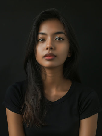 Portrait of a beautiful young Asian woman on black background.の素材