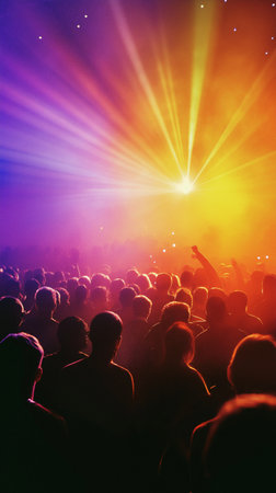 Silhouette of a crowd at a concert with bright rays of lightの素材