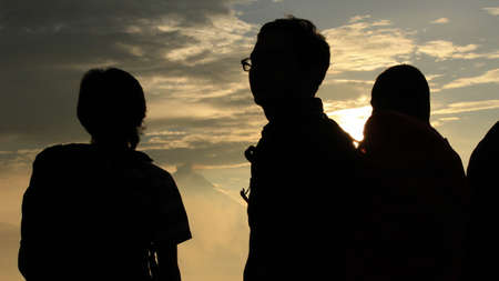 Group of people silhouette at golden sunriseの写真素材