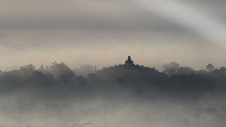 The morning mist and sunrise make the silhouette painting of Borobudur Temple even more beautiful