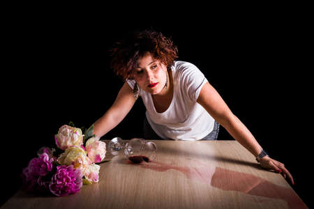 Woman, wine and flowers on a black background