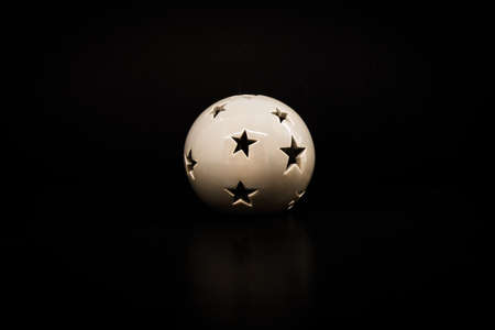 ceramic candle holder ball with star-shaped holesの写真素材