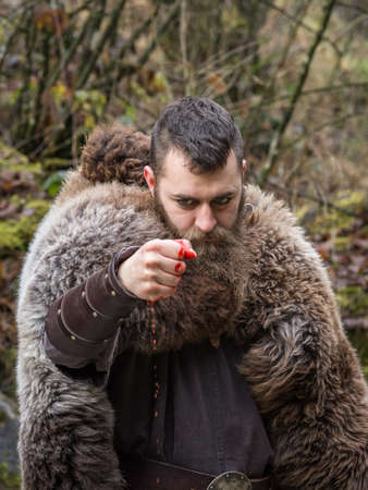 an ancient Viking warrior clenches the fist of his bloody handの写真素材