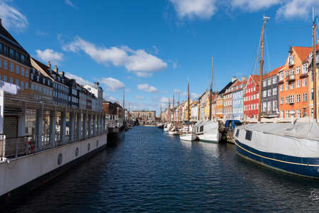 Nyhavn Canal under a blue sky with some clouds, ancient port in the center of the city of Copenhagen