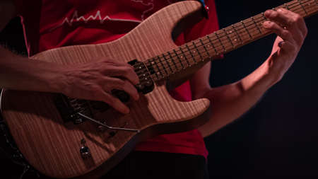 detail of hand playing an electric guitar, color image