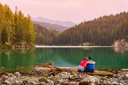 Loving couple sitting on the edge of the Pragser Wildseeの写真素材
