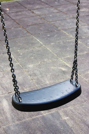 Empty dark sturdy swing on a playground, isolated の写真素材