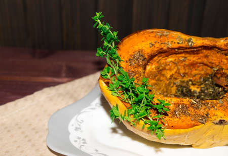 Pumpkin Baked with spices and decorated with thyme on plate toned selective focusの写真素材