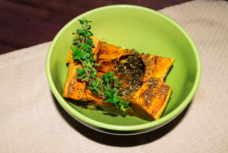 Pumpkin baked with spices and decorated with thymeの写真素材