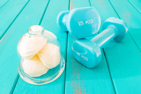 Zephyr in mini glass dome and dumbbells on bright planks toned selective focusの写真素材