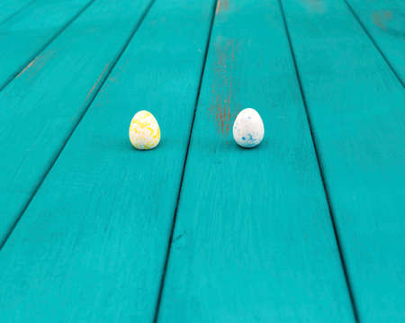 Pair of Easter Eggs on bright azure wooden planks toned selective focusの写真素材