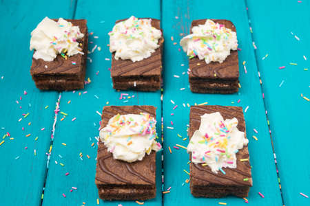 Brownies decorated with whipped cream and sugar frosting top view toned selective focusの写真素材