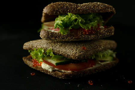 Fresh green sandwich with caviar and cream cheese selective focus darkの写真素材
