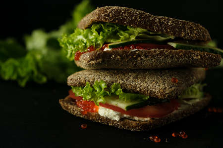 Fresh green sandwich with caviar and cream cheese selective focus darkの写真素材