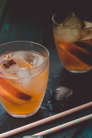 Peach aperol spritz with peach slices on wooden desk. Summer cocktails. Cold peach lemonade.