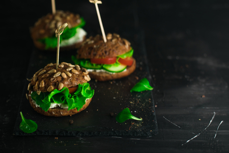 Green sandwich with salad, tomatoes, cucumbers and cream cheese.の写真素材