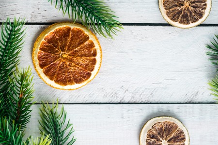 Christmas fir branches with different decoration - citrus slices, sparkling balls and pine cones.