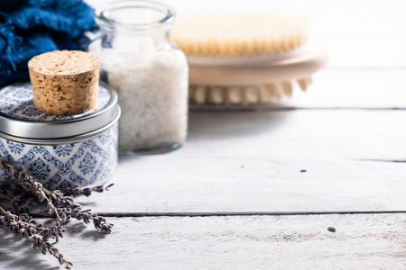 Spa wellness concept with lavender, essential oils and sea salt on wooden desk.