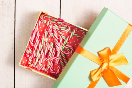 Lots of candy canes in gift box with big bow. Chtistmas theme.の写真素材
