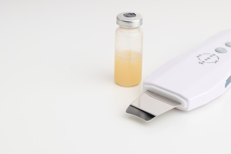 Ultrasonic skin spatula with serum in glass. Salon skin care.の写真素材