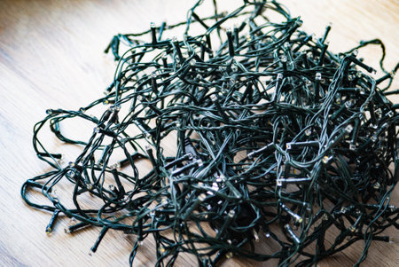New Year's garland with bulbs on a wooden background. Doesn't glow. Green wireの写真素材