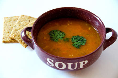 Delicious spicy bean soup in an earthenware dish on a white backgroundの写真素材