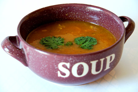 Delicious spicy bean soup in an earthenware dish on a white backgroundの写真素材