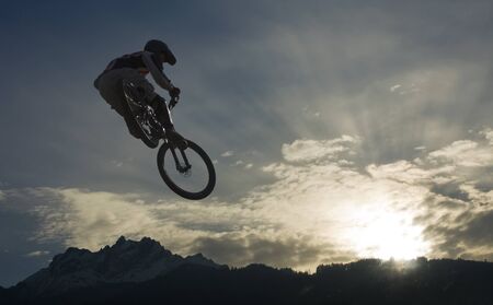 mountainbike jump against skyの写真素材