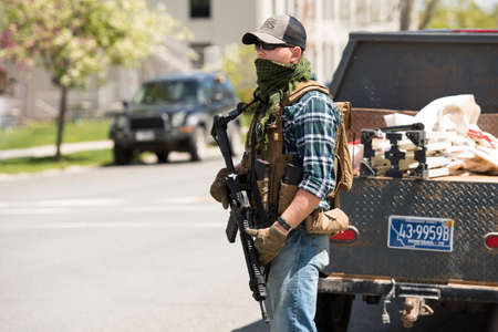 Helena, Montana - May 20, 2020: An armed man, militia member, protest at the Capitol building, holding a semi-automatic weapon in a street at the capitol, member of The Continentals with a gun.のeditorial素材