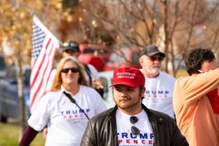 Helena, Montana / Nov 7, 2020: Pro-Trump supporter protesting at #stopthesteal rally at the Capitol wearing Make America Great Again red hat against the media declaring Joe Biden president electのeditorial素材