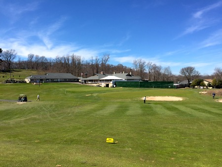 Long Island, NY - Circa 2017: Smithtown Landing Beautiful golf course and pro shop view in background. Golfer players on fairway to chip ball onto green for putt.のeditorial素材
